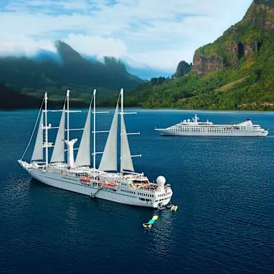 Sailing cruise ship anchored off a green island in Tahiti